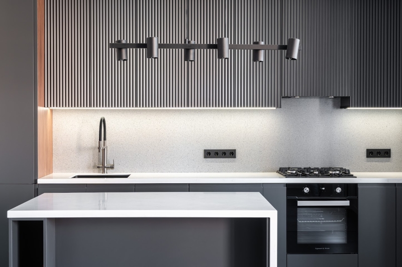 Освітлення кухні Три підвісних світильники з регульованою висотою над кухонним островом для зручності готування.