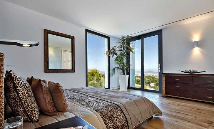 Затишна гостьова спальня Сучасний дизайн гостьової спальні вілли з використанням природних матеріалів та панорамних вікон.