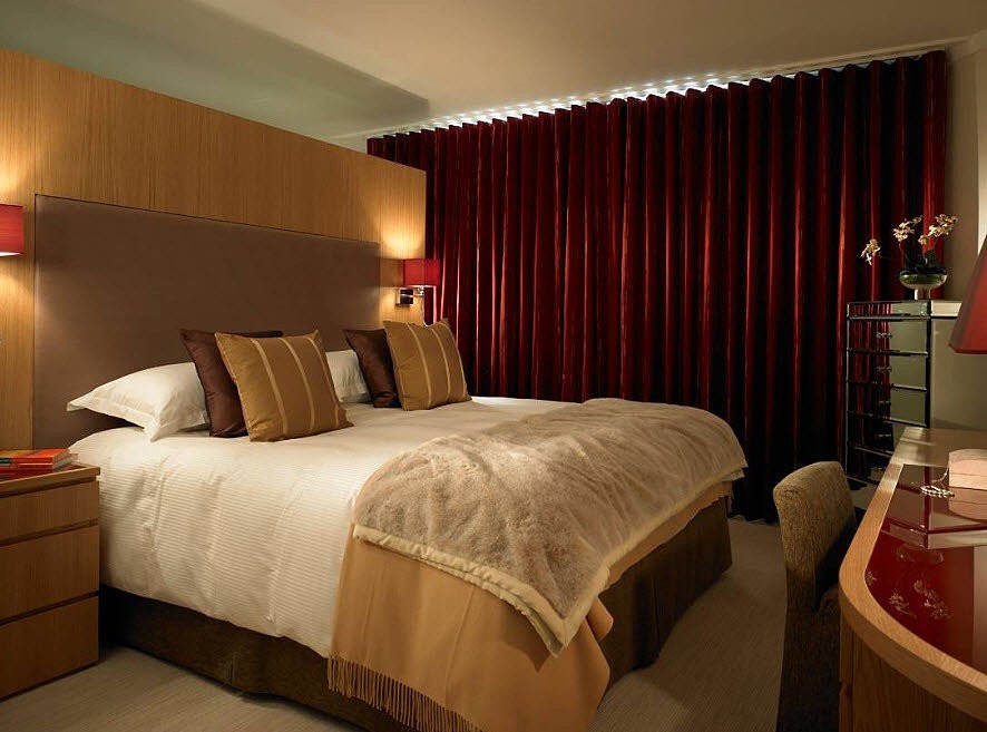 Бордові штори: висота Довгі бордові штори в інтер'єрі з високими стелями, візуально збільшують простір.