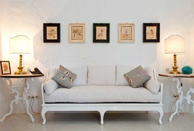 Вітальня у середземноморському стилі Вітальня в середземноморському стилі з білими стінами, дерев'яними меблями та великими вікнами, 2026.