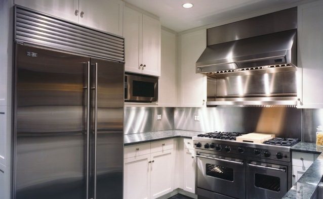 Сталевий фартух Кухонний фартух з нержавіючої сталі візуально збільшує простір чорно-білої кухні.