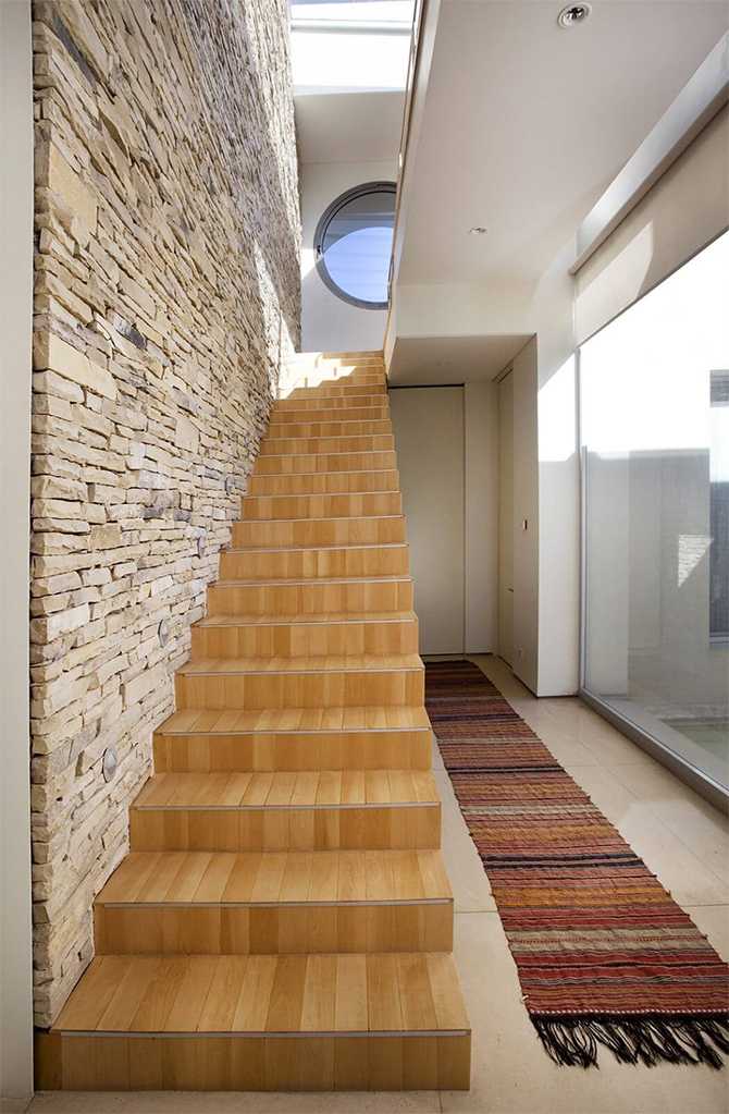 Сходи: Простір та стиль Стильні сходи в будинку з великим склінням, що ведуть на другий поверх.
