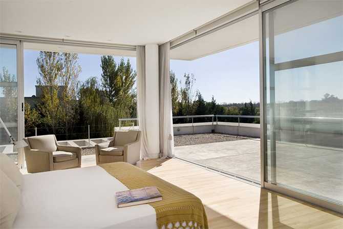 Еко-спальня: Гармонія Сучасна спальня в стилі еко-дизайну з використанням натуральних матеріалів та великим вікном.