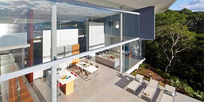 Скляний дім зверху Вид зверху на скляний будинок на узбережжі океану, сучасний дизайн та басейн