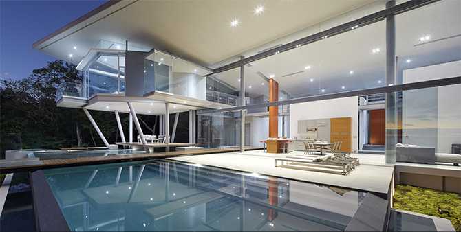 Скляний дім вночі Скляний будинок вночі з підсвіткою на березі океану, сучасний дизайн 2026