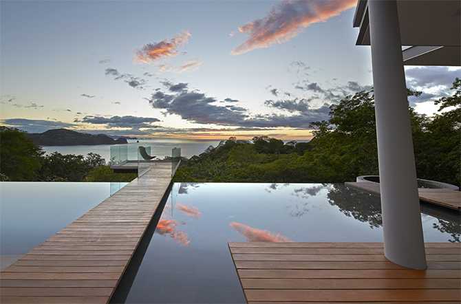 Два басейни Два басейни біля скляного будинку на обриві, сучасна архітектура та відпочинок