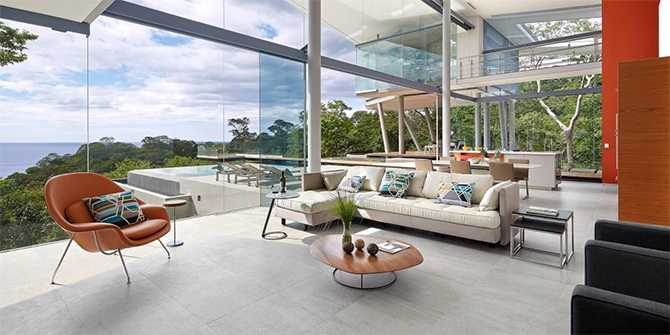 Вітальня з видом Інтер'єр вітальні в скляному будинку з панорамним видом на океан, сучасний дизайн