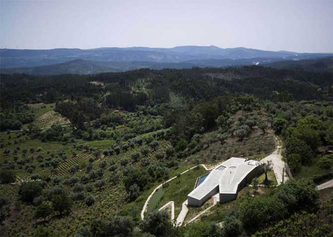 Будинок та природа Вид зверху на сучасний будинок з плоским дахом, що гармонійно вписаний в ландшафт