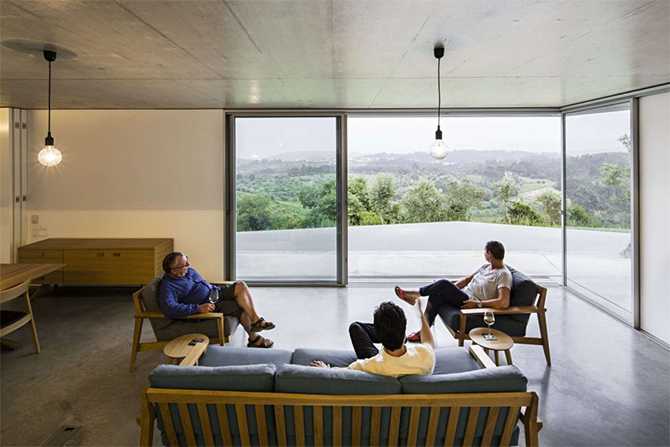 Вітальня з видом Проект будинку з плоским дахом: сучасна вітальня з великими вікнами та видом на природу