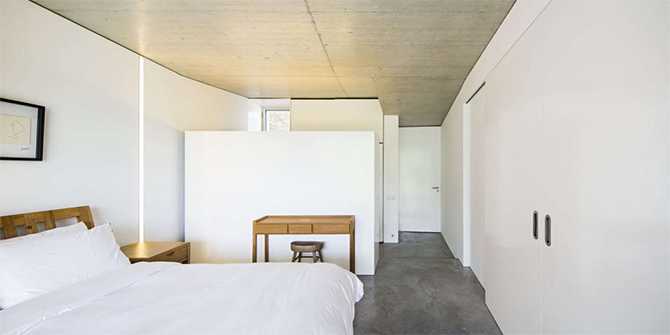 Спальня: затишок та мінімалізм Сучасний стиль: спальня господарів з плоским дахом та видом на природу в домі на схилі