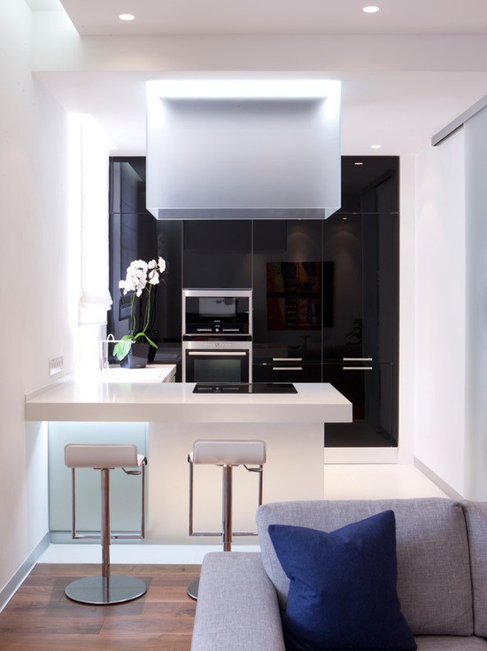 Контрастний кухонний дизайн Дизайнерська кухня з чорним глянцевим фасадом та білою матовою барною стійкою для контрасту.