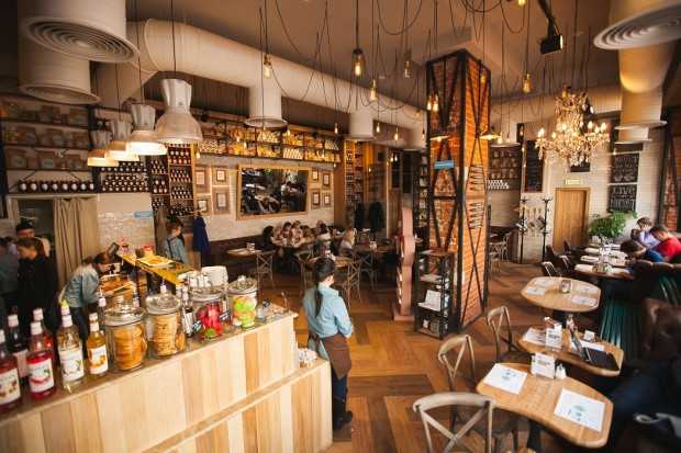 Кав'ярня: загальний план Загальний вигляд інтер'єру кав'ярні в стилі лофт, розроблений Cross Art Studio