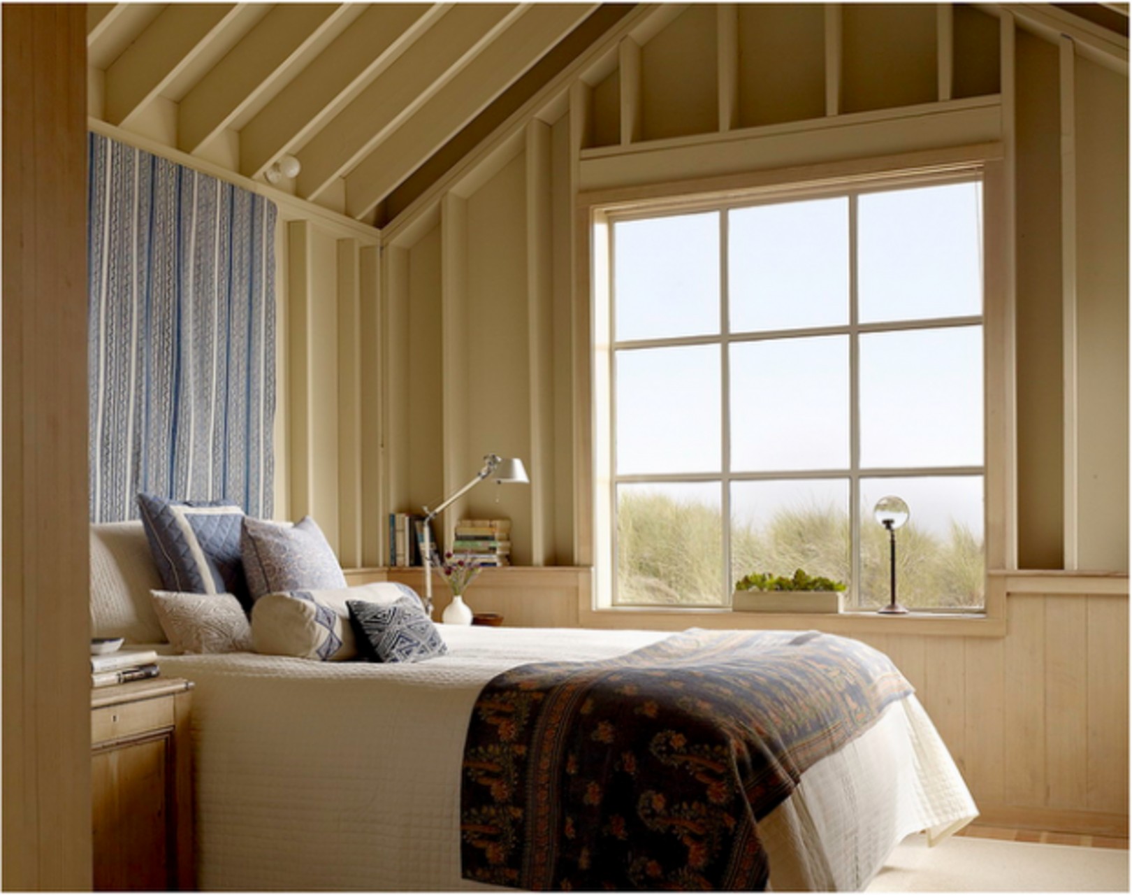 Кухня з видом на пляж Кухня в будинку на пляжі: дерев'яні шафи, плетений декор та цегляна стіна.