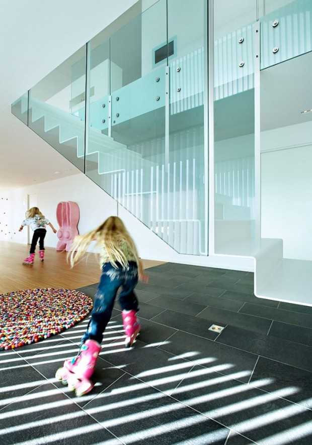 Простора вітальня з вікнами Архітектура в світлих тонах: інтер'єр норвезької вілли з просторою вітальнею та великими скляними просторами.