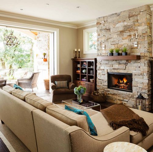 Камінь біля дивана у вітальні Оздоблення декоративним каменем стіни у вітальні, прилеглій до зони відпочинку з диваном