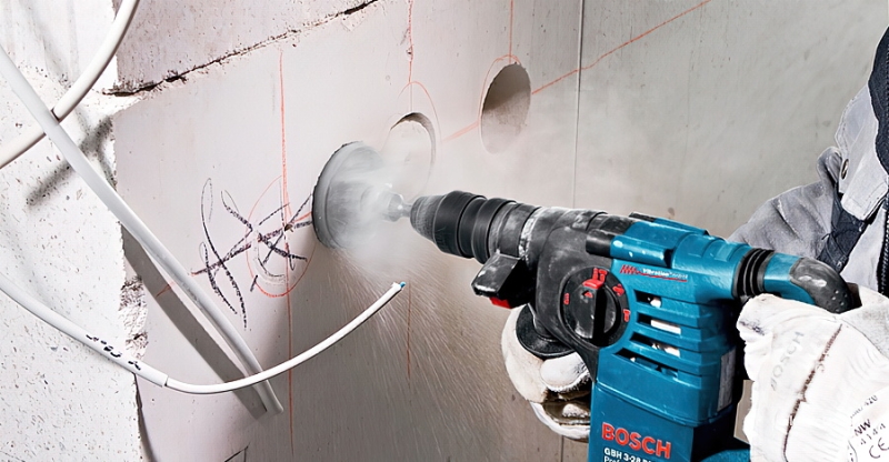 Свердління бетону Процес висвердлювання отвору в бетонній стіні під підрозетник за допомогою перфоратора.