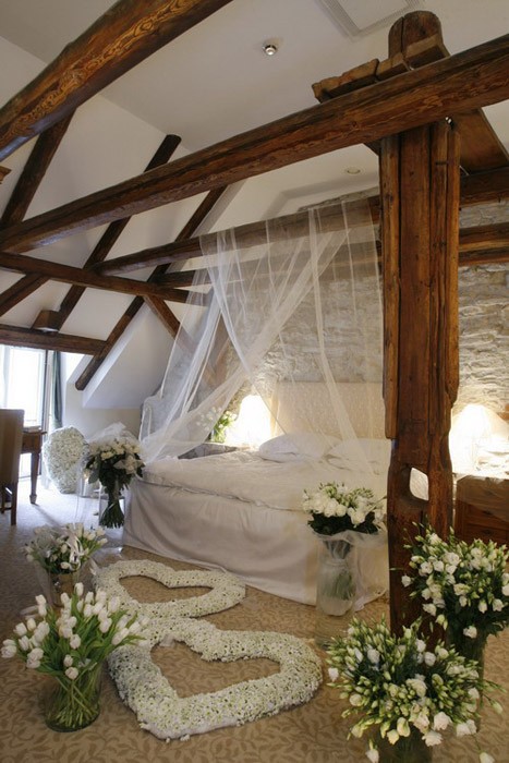 Серце в інтер'єрі Оформлення кімнати для романтичного вечора: подушки у формі серця та м'яке покривало.