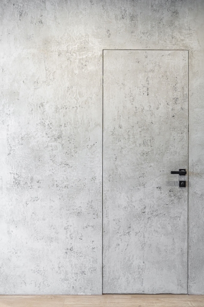 Приховані двері Двері прихованого монтажу, оздоблені декоративною штукатуркою в сучасному інтер'єрі.