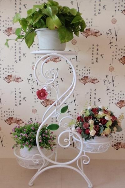 Квіти у спальні Біла кована підставка для квітів, витончений акцент в інтер'єрі спальні.