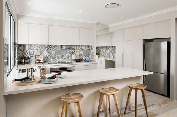 Кремова світлість кухні Світла кремова кухня з великим вікном, що забезпечує природне освітлення та заспокійливу атмосферу.