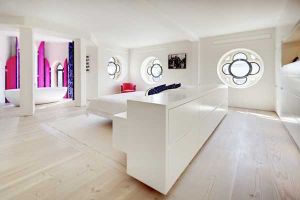 Лофт у церкві Лофт дизайн 2026: світла вітальня з арочними вікнами у переобладнаній вікторіанській церкві.