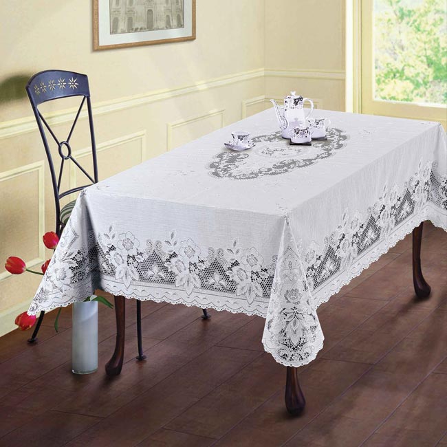 Ажурна романтика Біла ажурна скатертина на дерев'яному столі, створює романтичну та вишукану атмосферу.