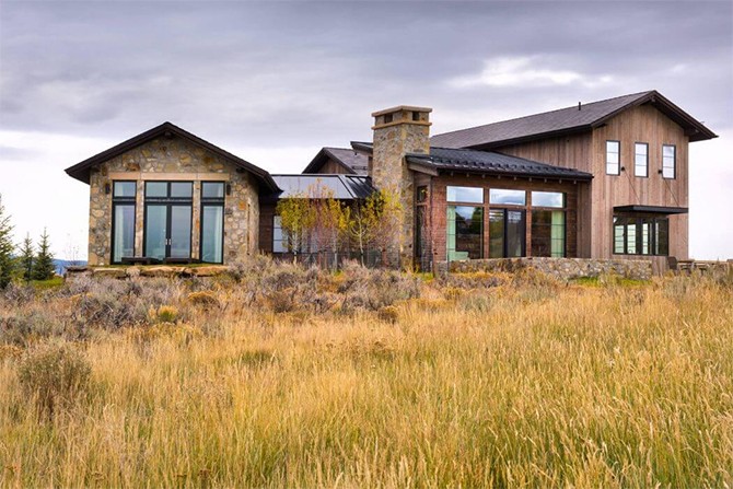 Фасад будинку Фасад особняка в американському фермерському стилі з металочерепицею, каміном та великими вікнами