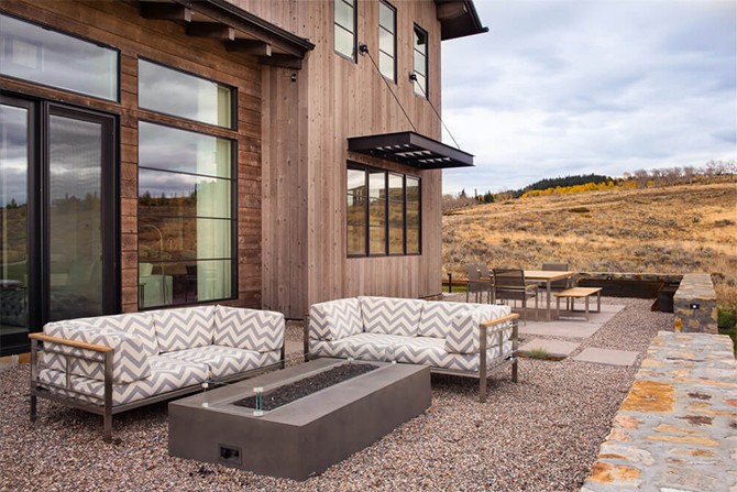 Тераса для відпочинку Затишна тераса в фермерському стилі з плетеними меблями та видом на сад