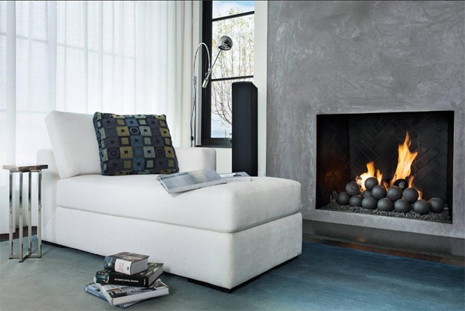 Місце біля каміна Зручне місце біля каміна з м'яким кріслом та теплим освітленням у фермерському стилі