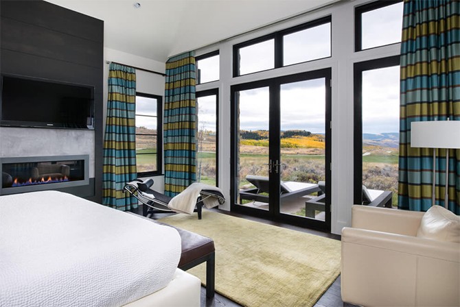 Фермерський затишок спальні Затишна спальня в фермерському стилі з натуральним каменем та великими вікнами.