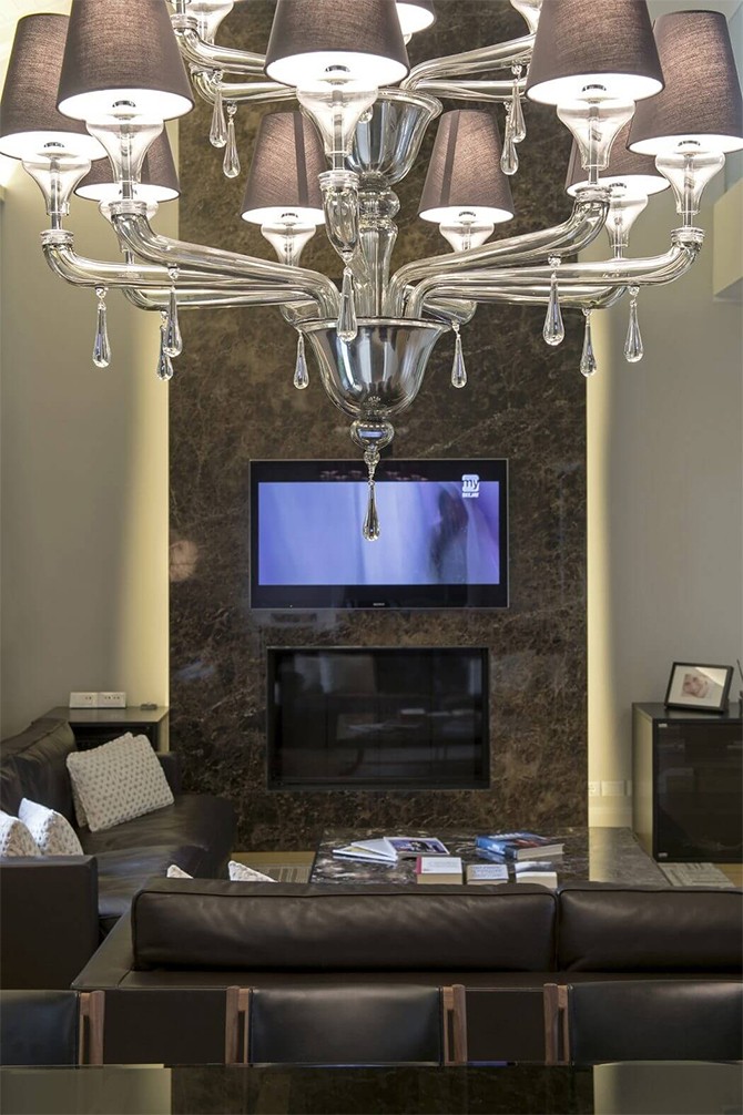 Люстра над каміном Елегантна люстра над каміном у шале, що додає розкоші та вишуканості.