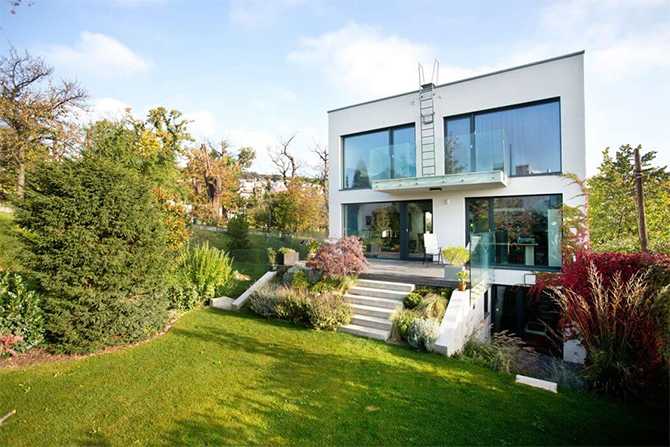 Вид на затишок Вид з внутрішнього двору на сучасний будинок з великими вікнами.