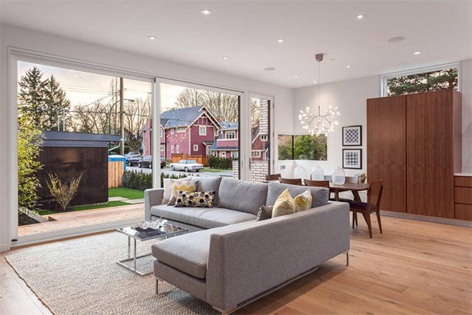 Вітальня з каміном Дизайн сучасного будинку: вітальня з каміном та великим диваном для сімейного відпочинку.