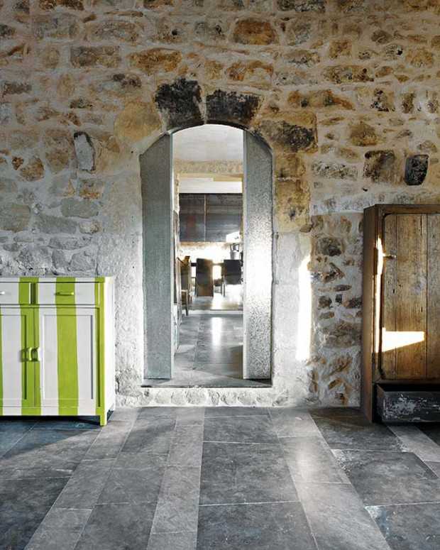 Рустикальна спальня Мінімалістична спальня в рустикальному стилі з кам'яними стінами в сицилійському будинку.