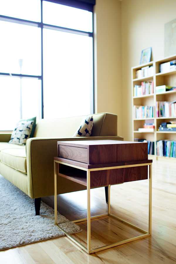 Елегантне доповнення інтер'єру Сучасна тумба з горіхового дерева та латуні біля дивана в мінімалістичному інтер'єрі
