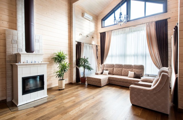 Освітлення: Затишок у деталях Інтер'єр вітальні в дерев'яному будинку з багаторівневим освітленням та натуральними елементами декору