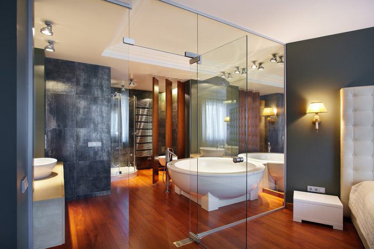Дизайн ванної кімнати Інтер'єр спальні з ванною кімнатою, де використано плитку під дерево та сучасну сантехніку.