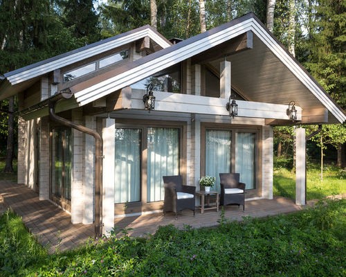 Класичний скандинавський дім Класичний скандинавський будинок з темним двосхилим дахом та дерев'яною обшивкою фасаду.